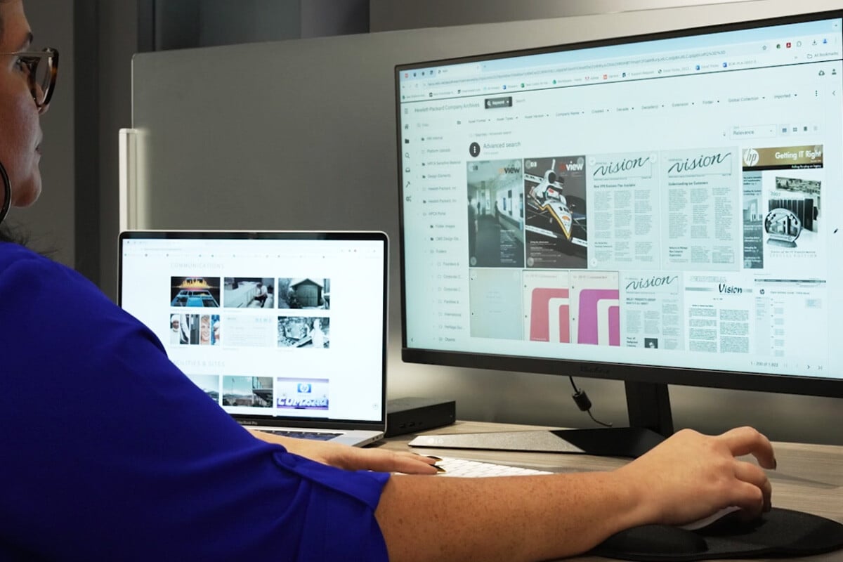 User accessing digital asset management system on dual screens to organize and search marketing and brand content