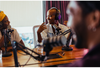 People recording an interview or discussion around a table