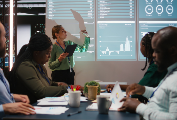 Business team reviewing materials in a meeting, representing how enterprise assets move across departments, markets, agencies and customer-facing channels