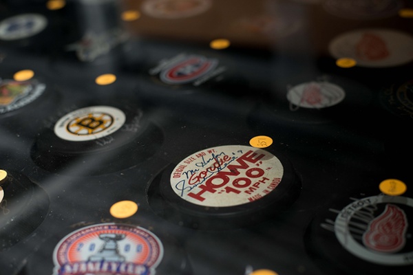 Collection of vintage NHL hockey pucks featuring team logos, including the Boston Bruins and Montreal Canadiens.
