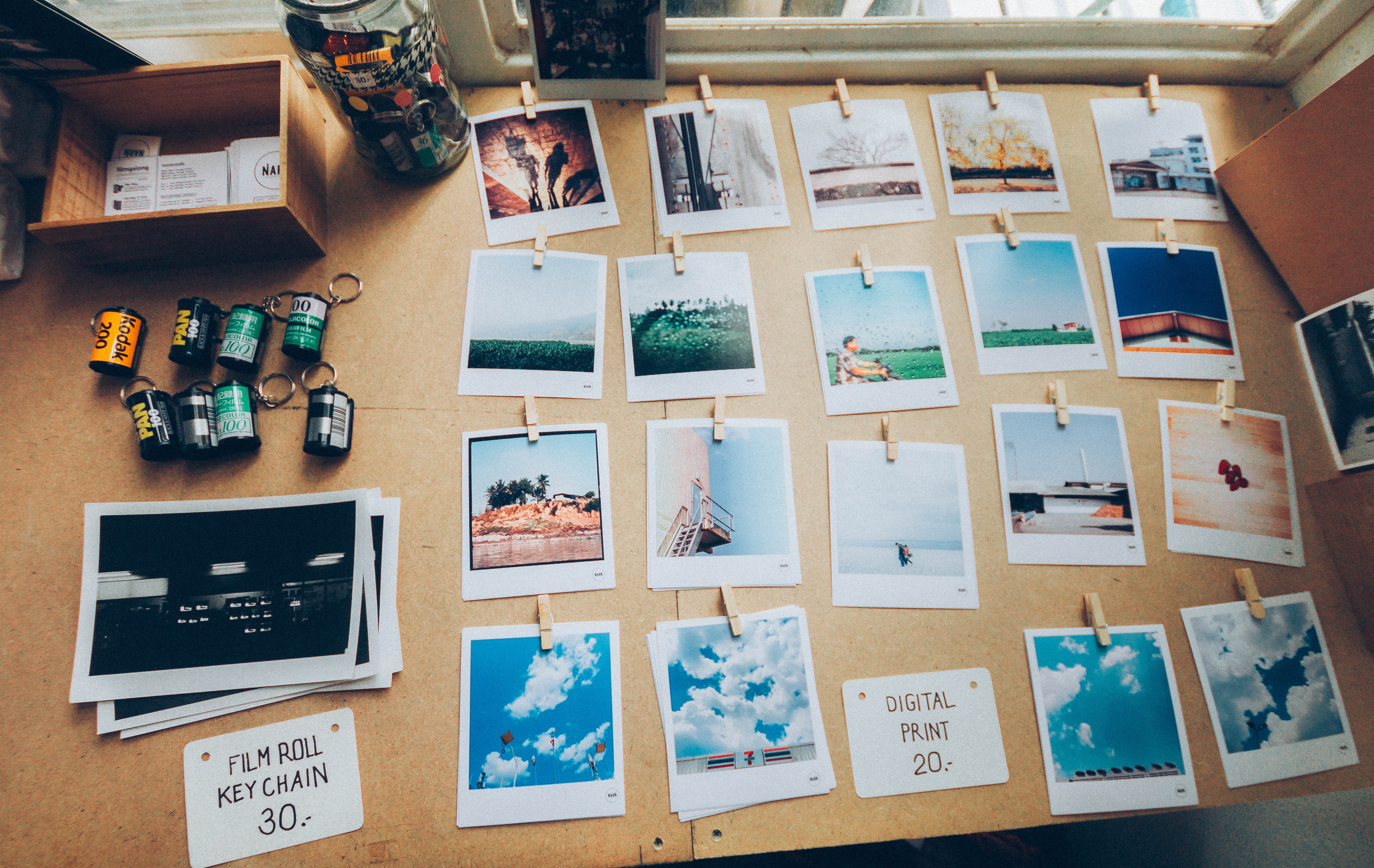 Printed photographs arranged in rows and clipped to strings, illustrating photo library organization.