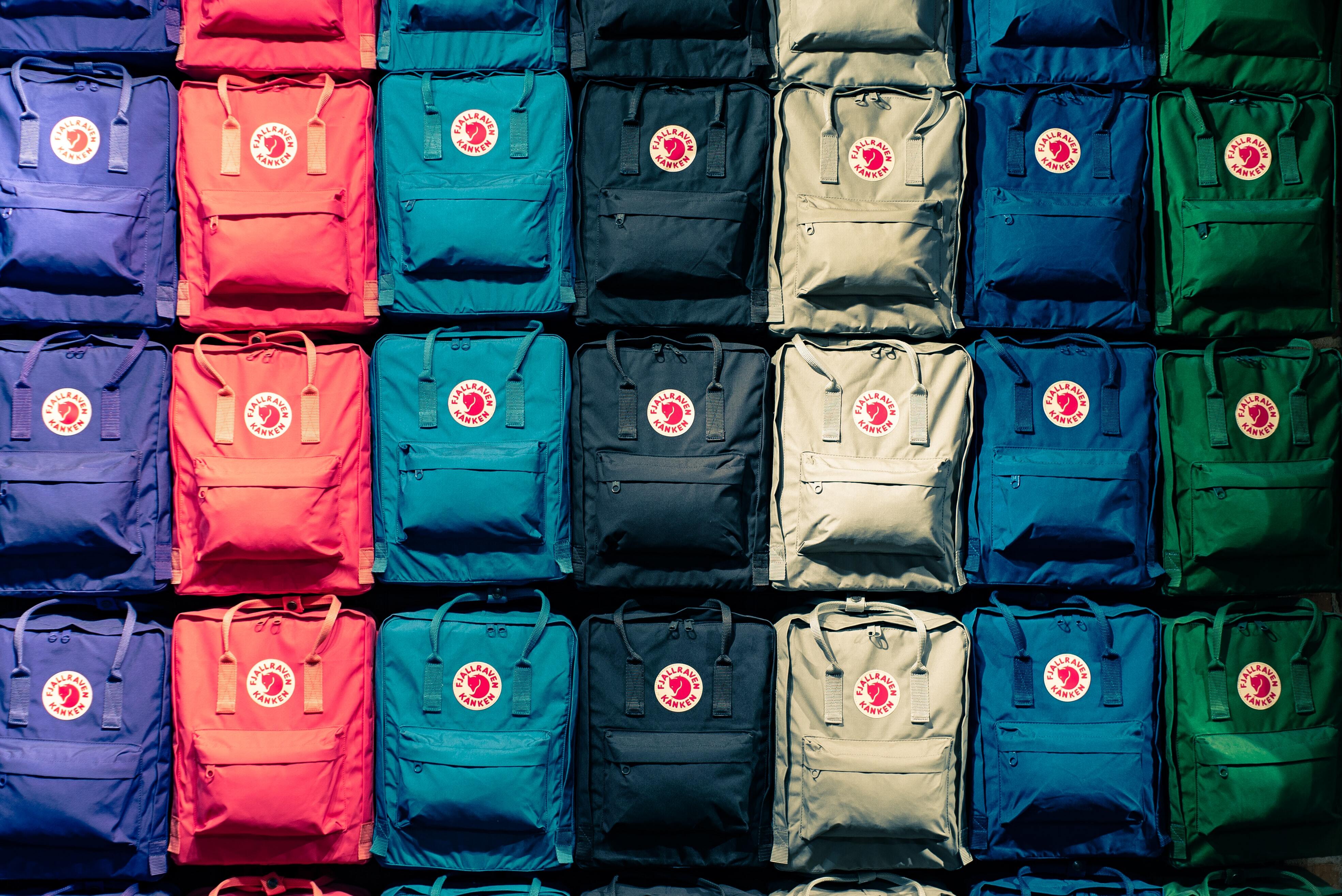 Rows of colorful backpacks illustrating consistent branding and visual asset organization.