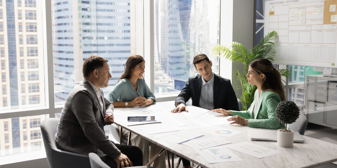  Four colleagues reviewing campaign plans around a conference table